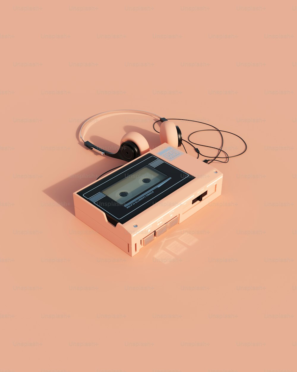 a cassette player with headphones on a pink background