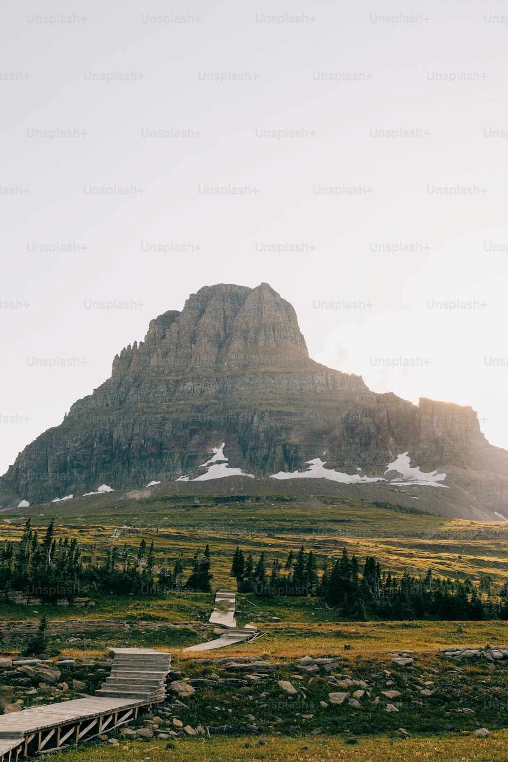 a large mountain is in the distance with a path leading to it