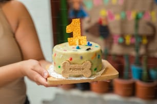 a person holding a cake with a dog on it