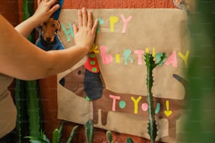Eine Frau, die einen Hund auf eine Geburtstagskarte setzt