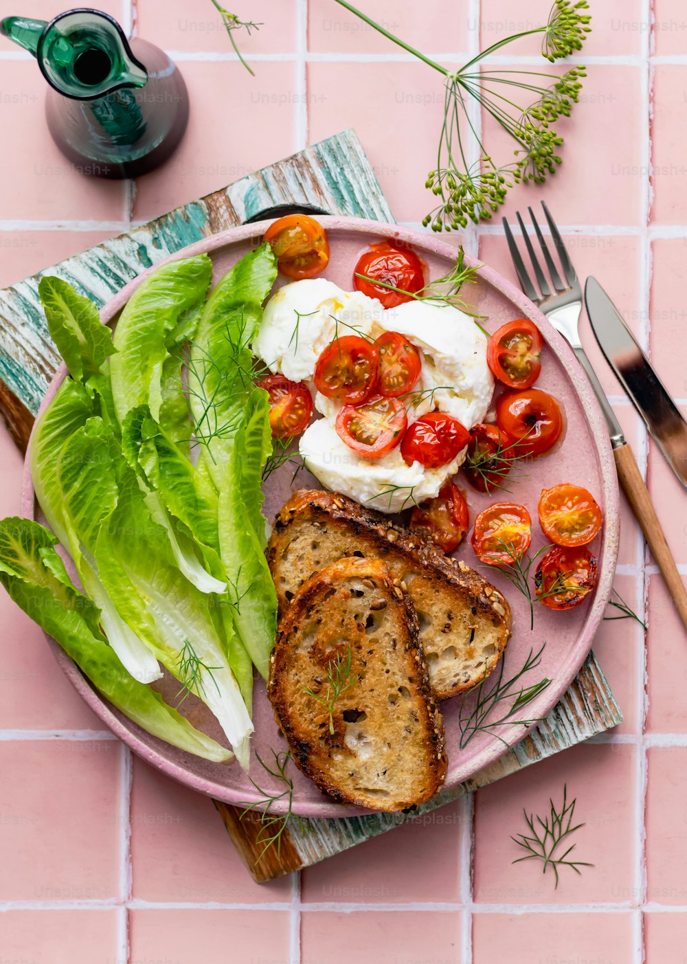a plate of food with bread, lettuce, tomatoes and eggs