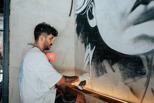Ein Mann malt ein großes Bild an eine Wand