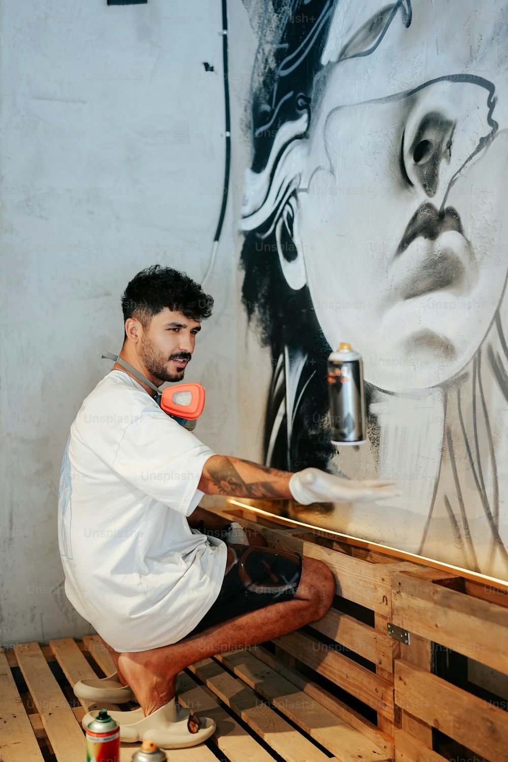Ein Mann, der ein Wandbild an eine Wand malt