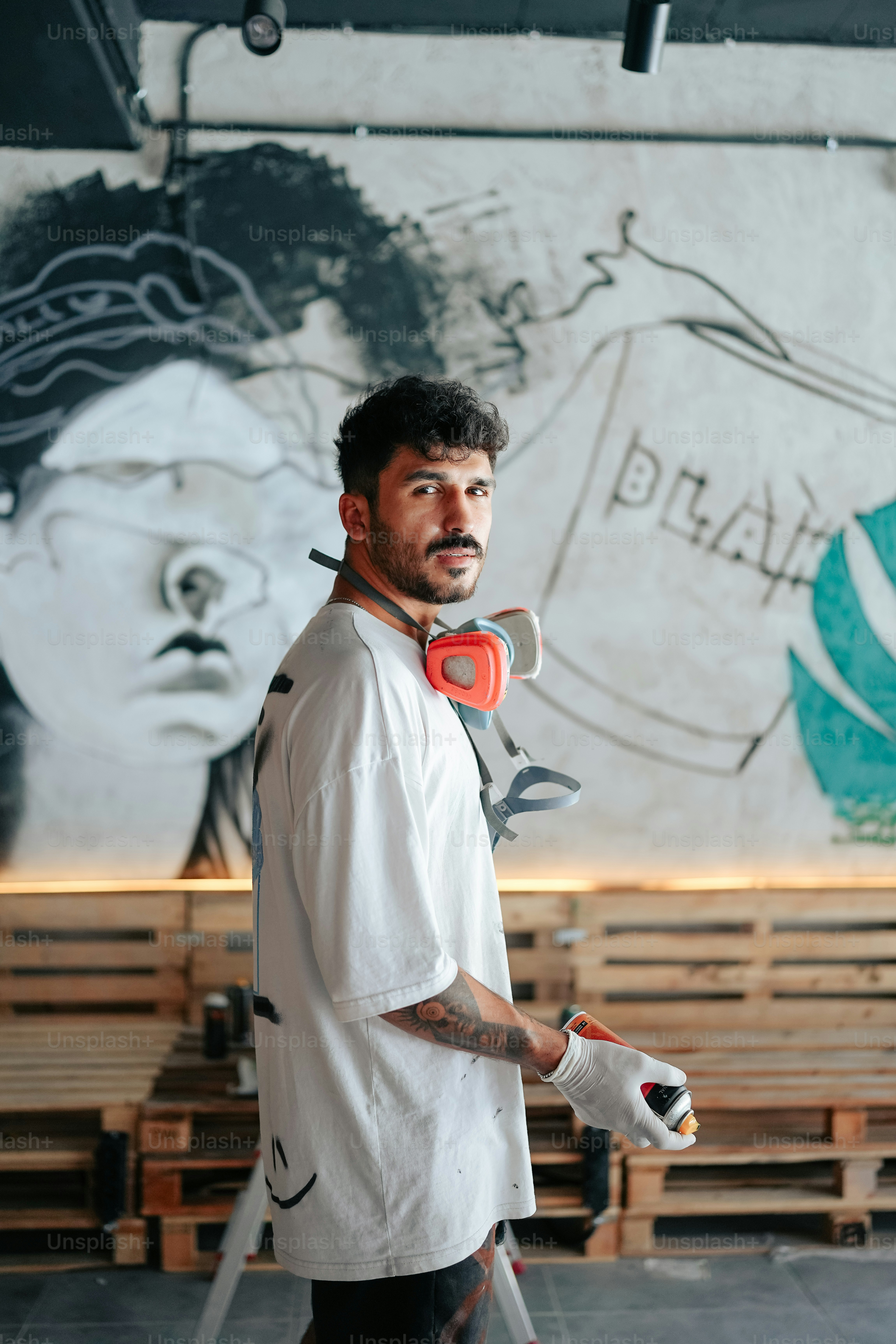 Un hombre parado frente a una pared con una pintura en ella foto ...