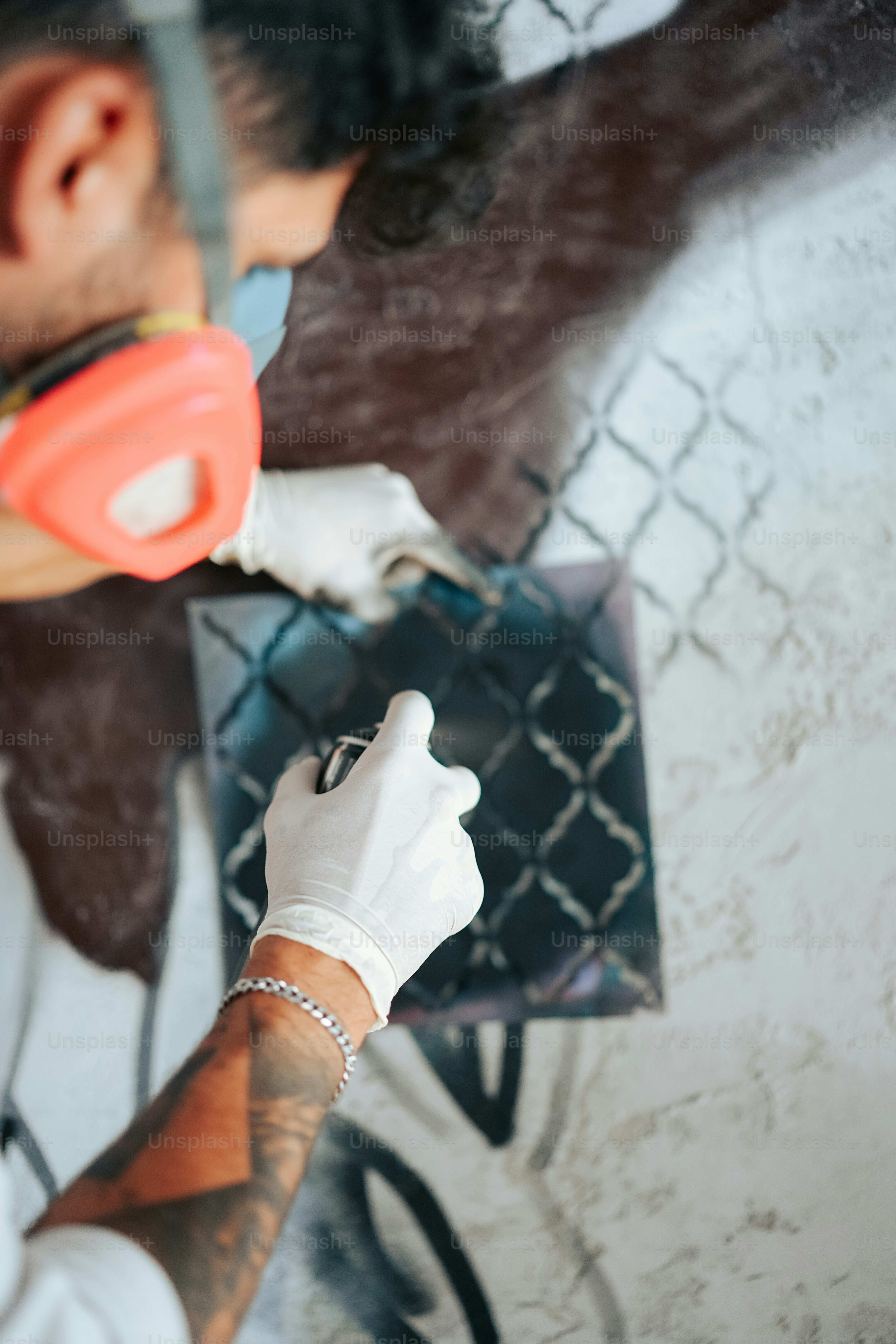 Ein Mann trägt eine Maske und Handschuhe, während er ein Handy hält