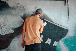um homem parado em frente a uma pintura de parede