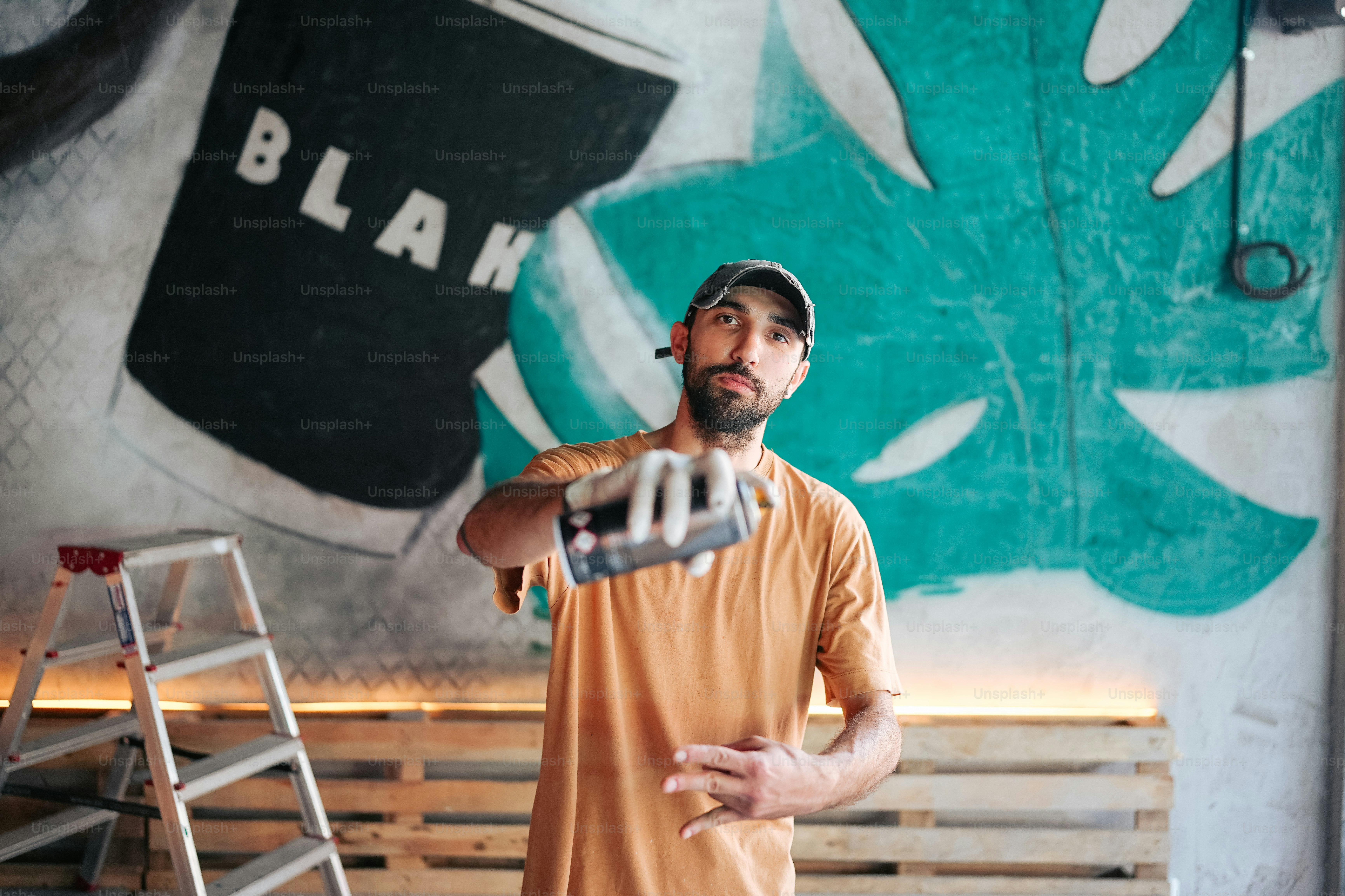 絵画の前でスケートボードを持つ男