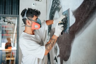 Un hombre pintando una pared con un rodillo de pintura
