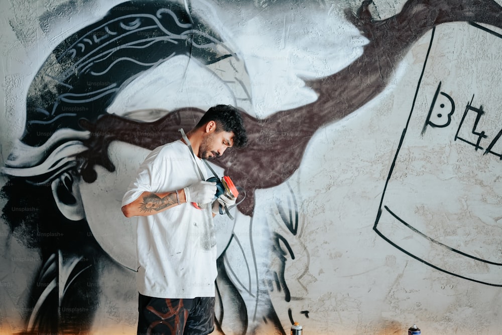 Un hombre parado frente a una pared con una pintura en ella