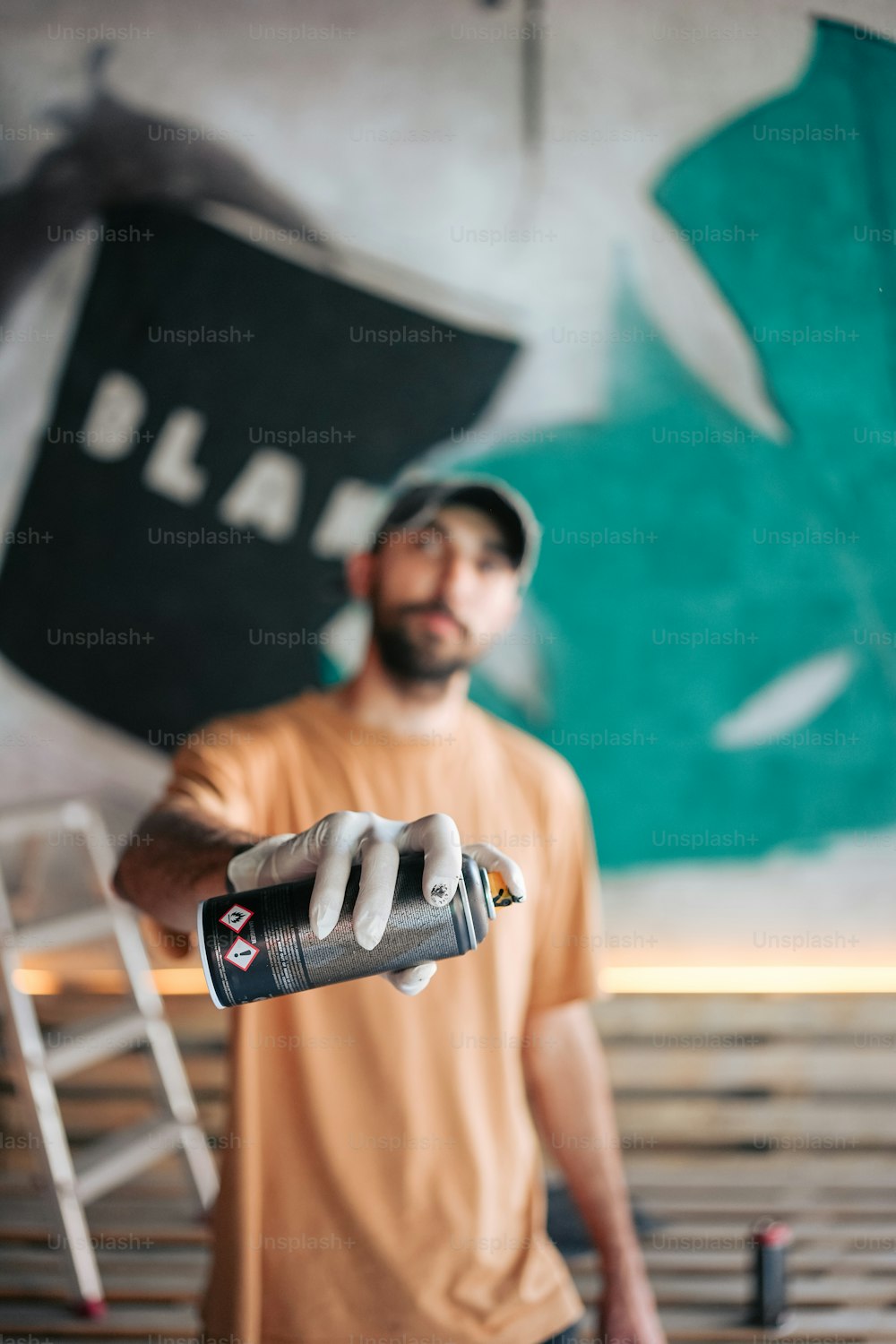 a man holding a paint roller in front of a painting