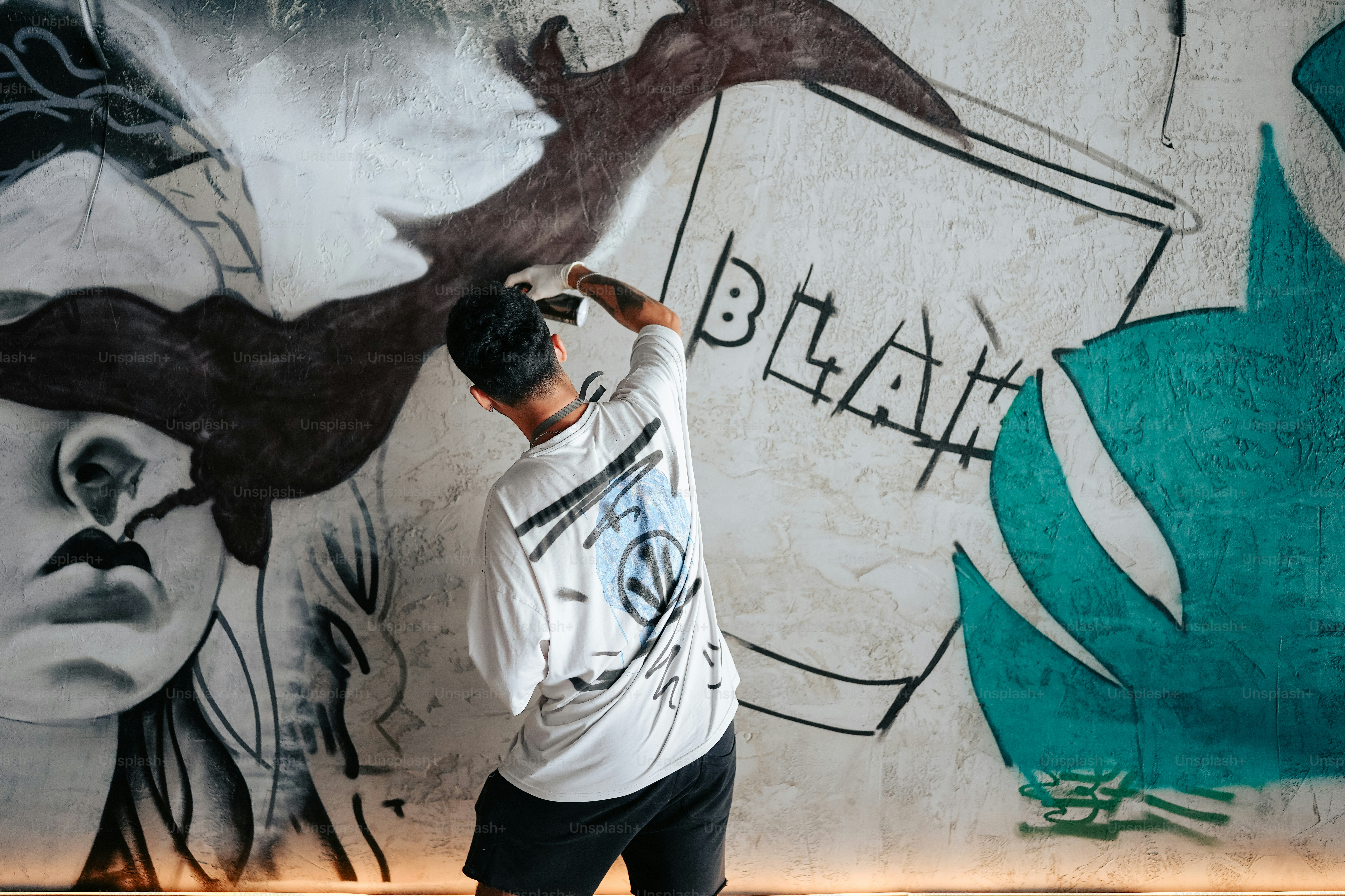 Ein Mann bemalt eine Wand mit Graffiti