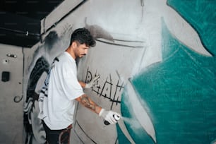 Ein Mann im weißen Hemd malt eine Wand