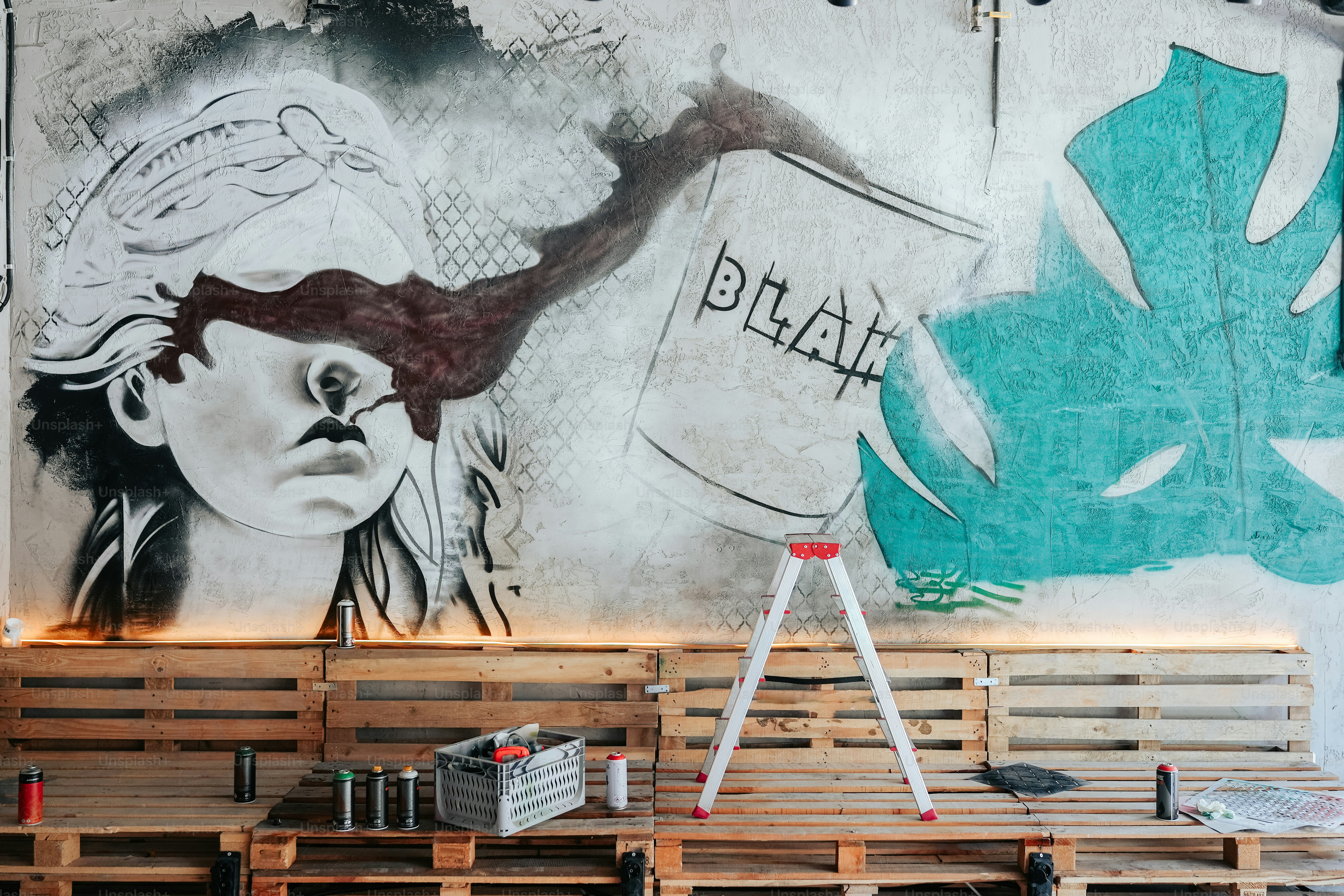 a painting of a woman on a wall behind a wooden bench