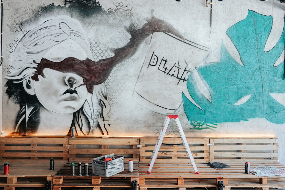 a painting of a woman on a wall behind a wooden bench