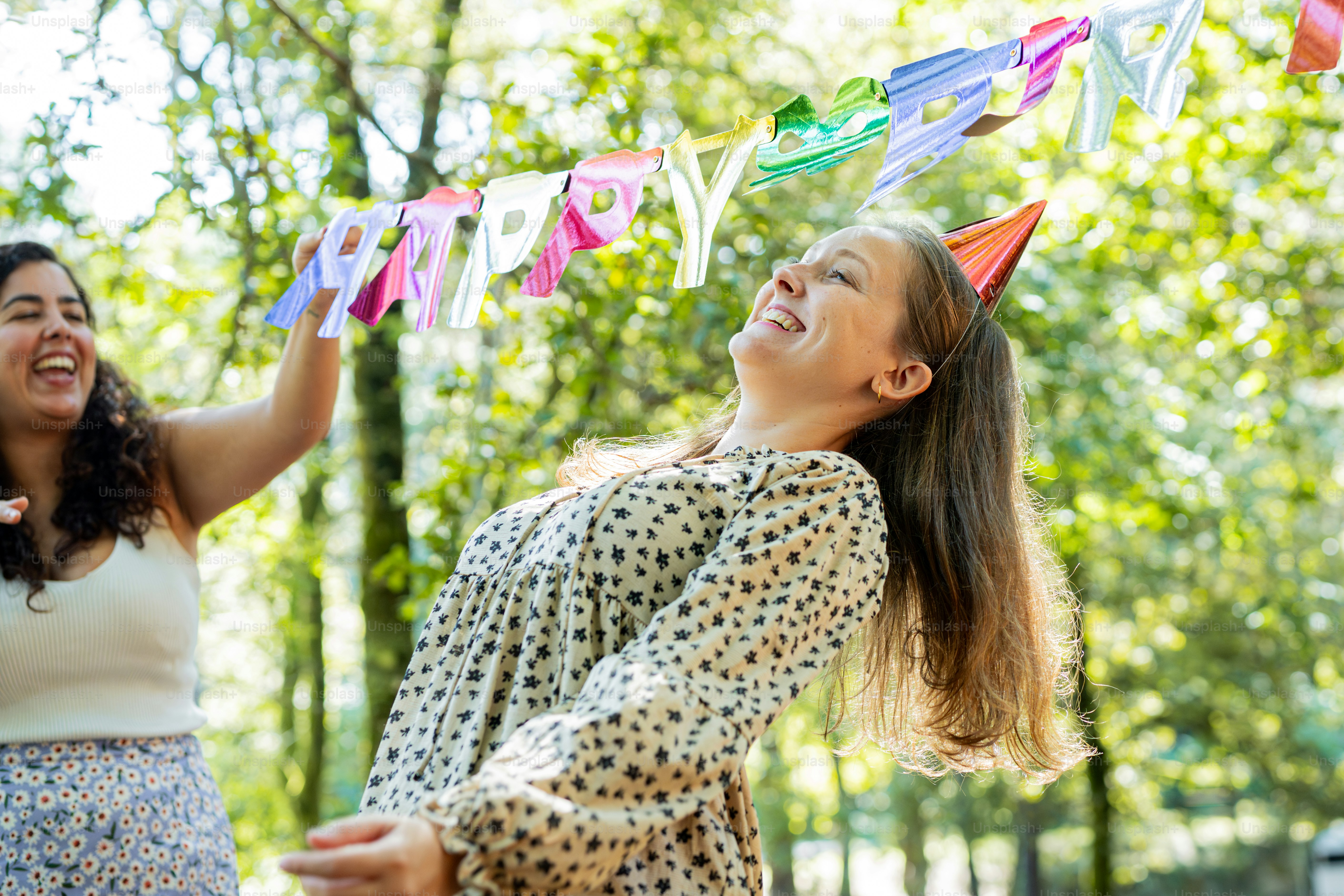 two women standing next to each other in a park