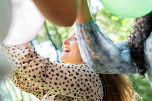 a woman holding onto a bunch of balloons