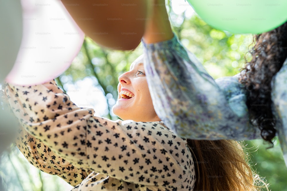 a woman holding onto a bunch of balloons