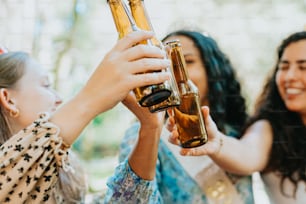 a group of women holding up bottles of beer