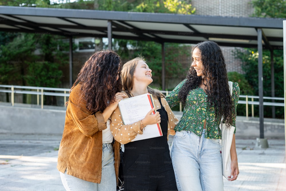 three young women are laughing together in front of a building