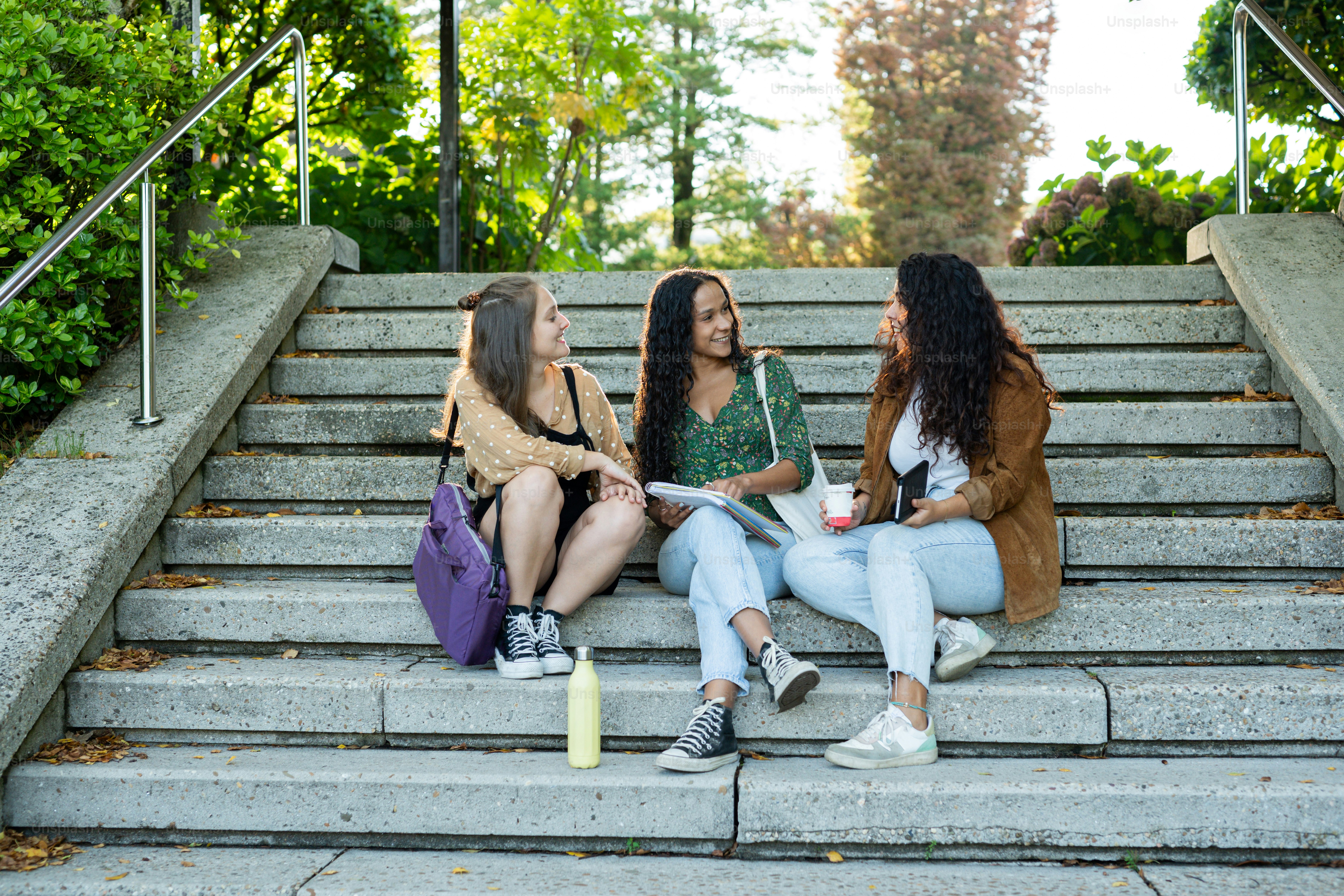 trois femmes assises sur des marches qui se parlent