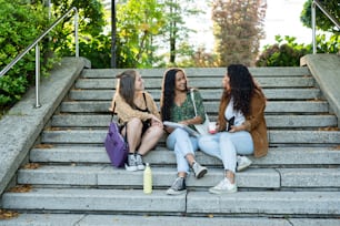three women sitting on steps talking to each other