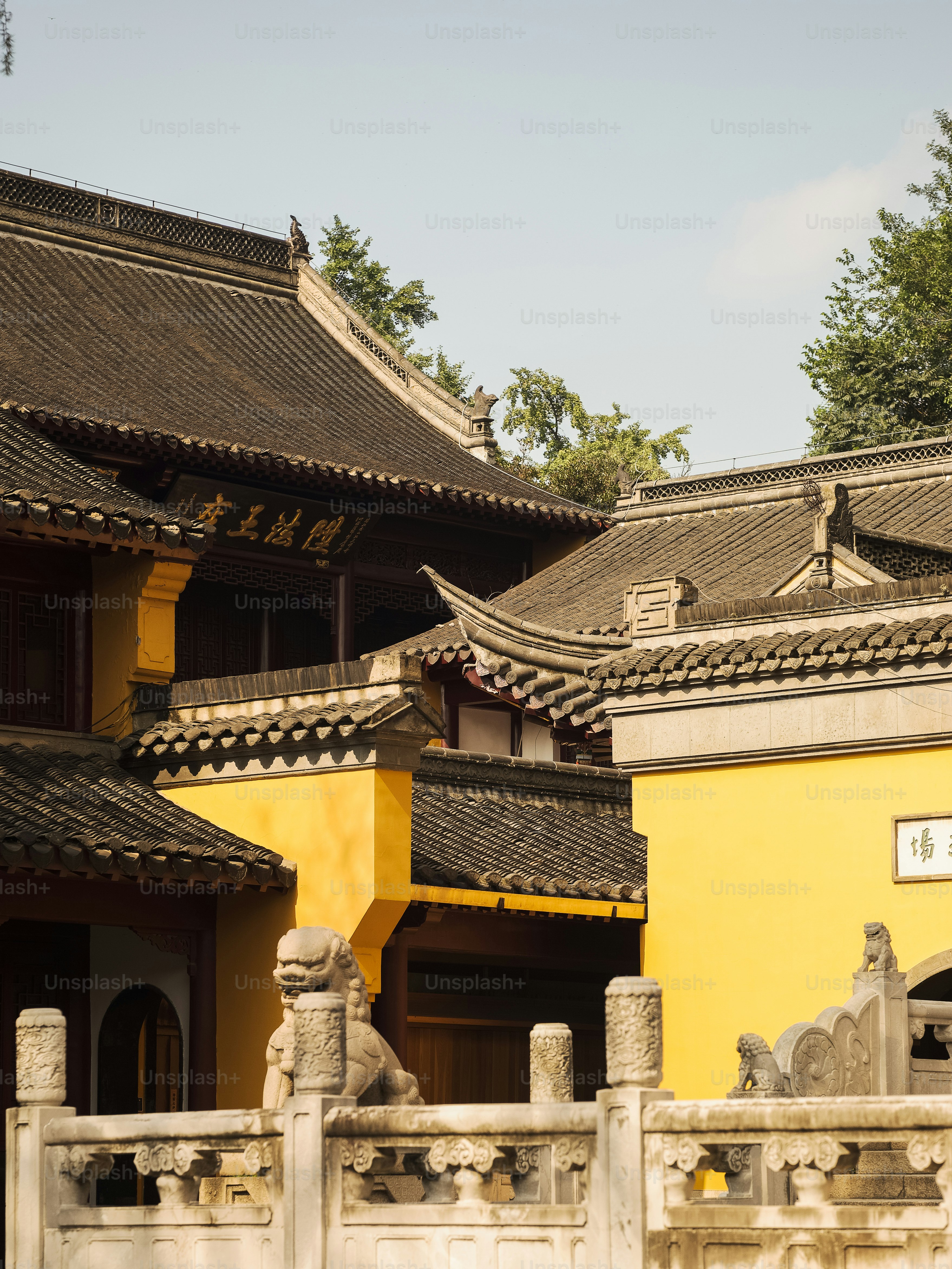 a yellow building with a white fence in front of it