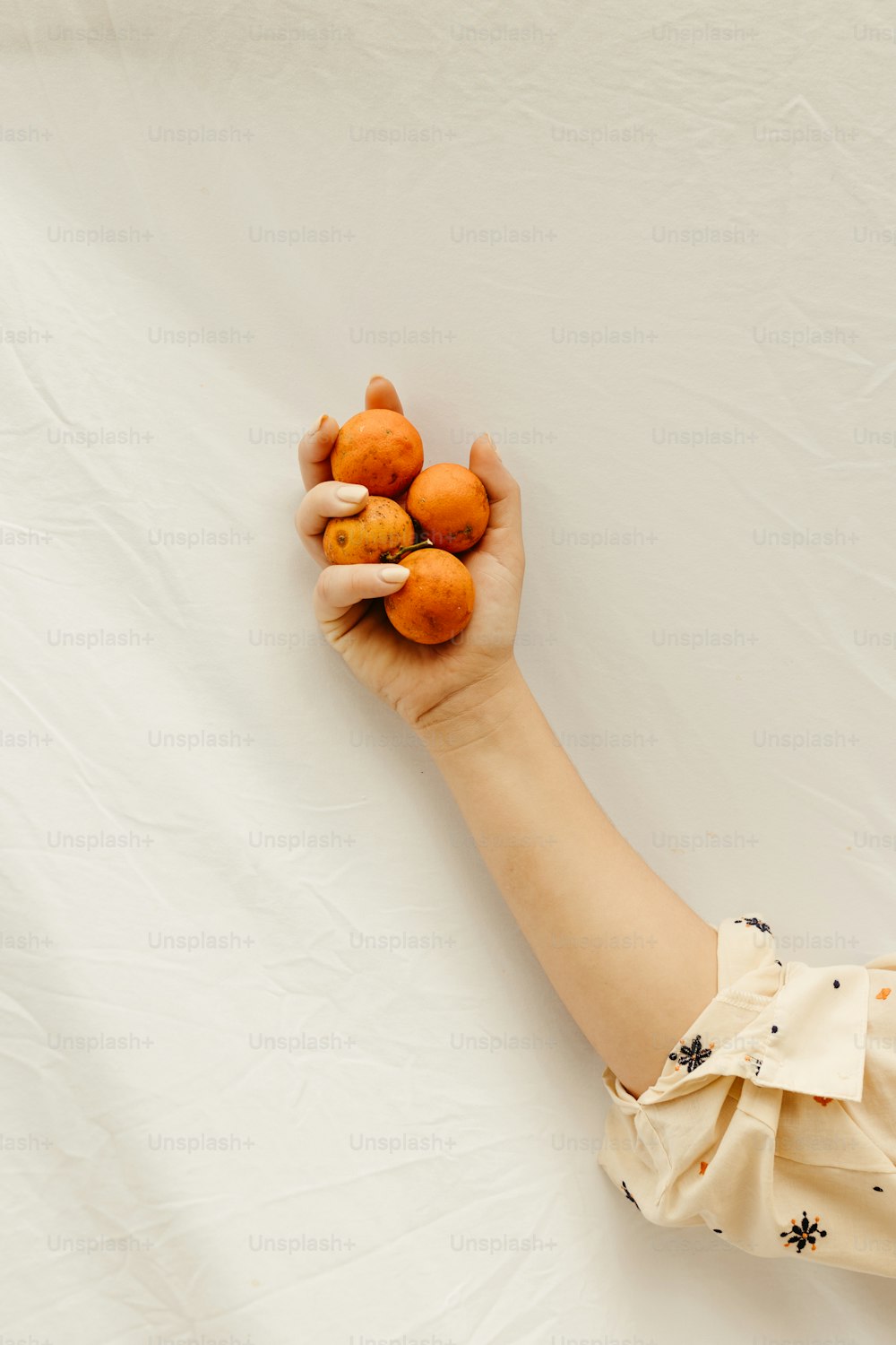 eine Person, die einen Strauß Orangen in der Hand hält