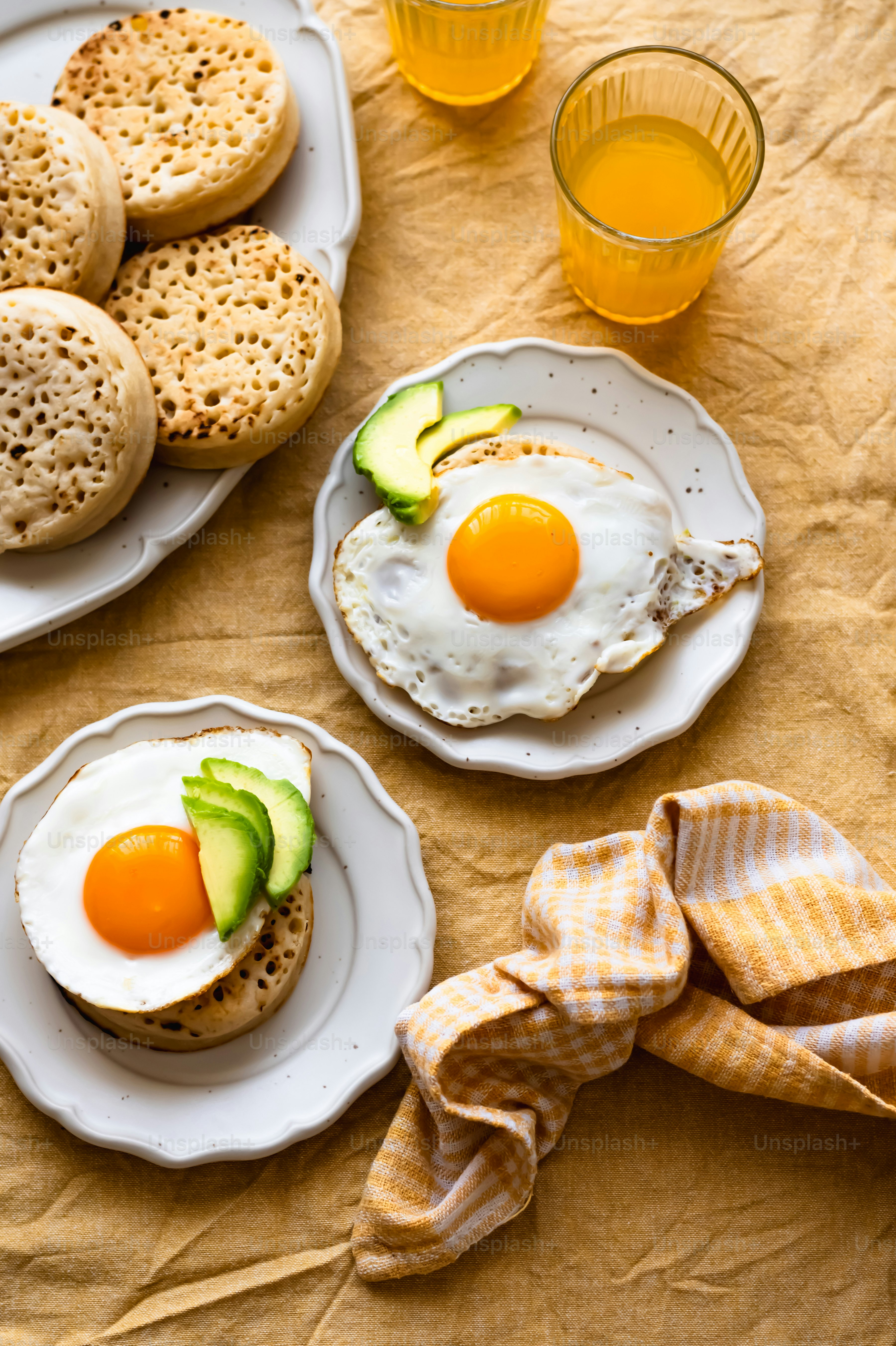 a table topped with plates of food and glasses of orange juice