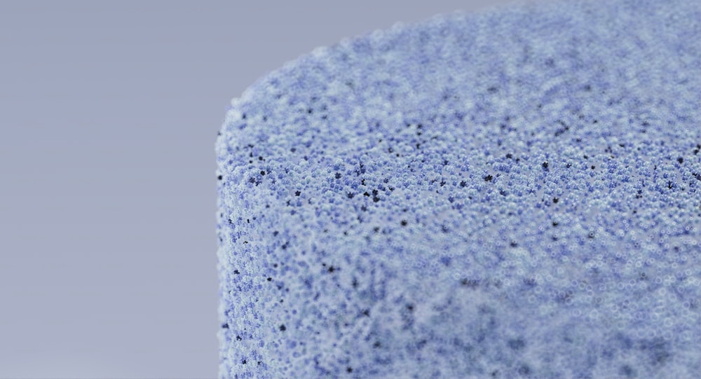 a close up of a blue surface with small dots