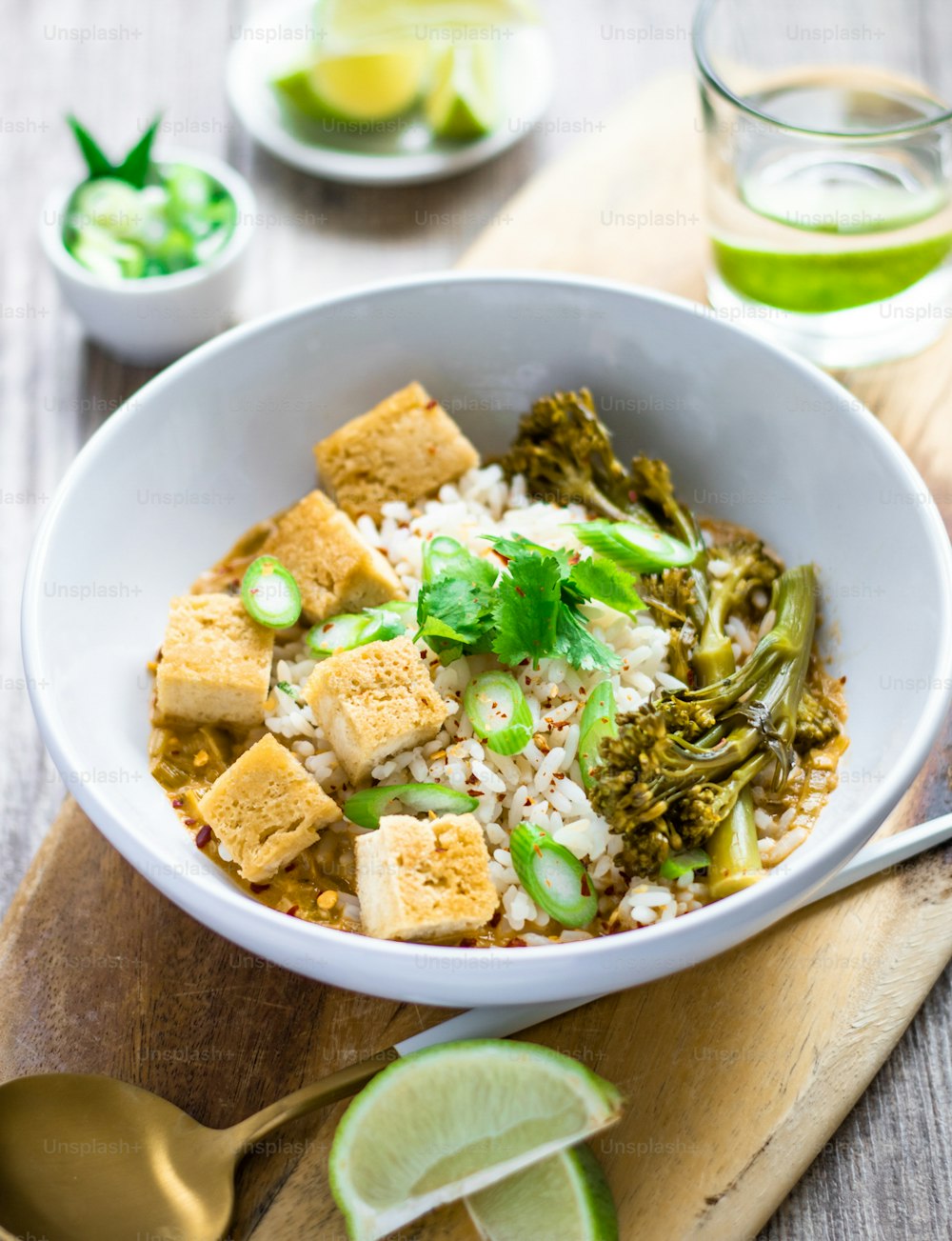 a bowl filled with rice, broccoli and tofu
