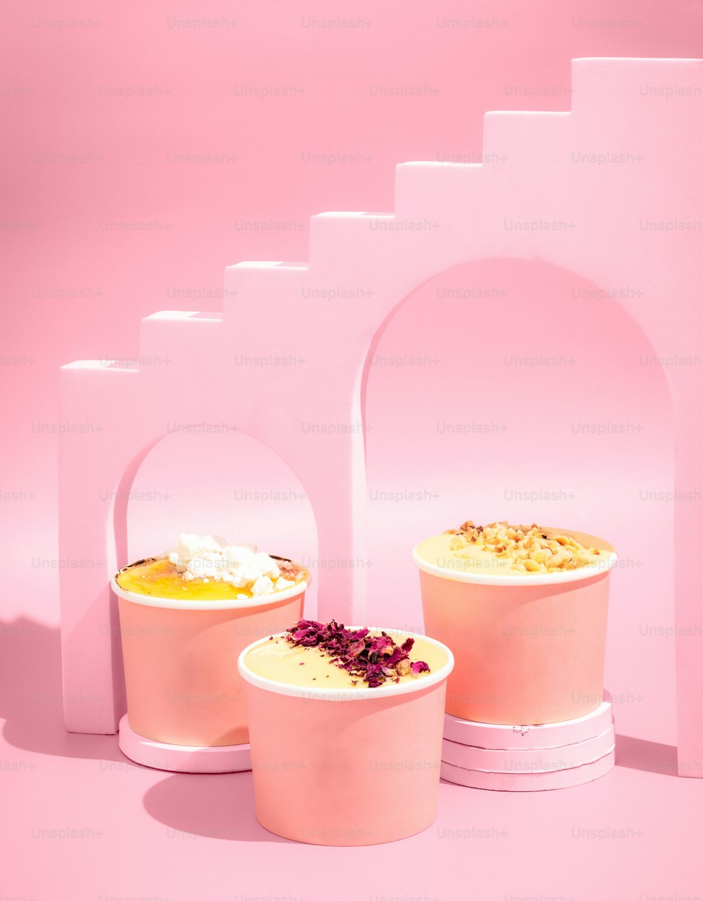 three ice cream containers with flowers in them