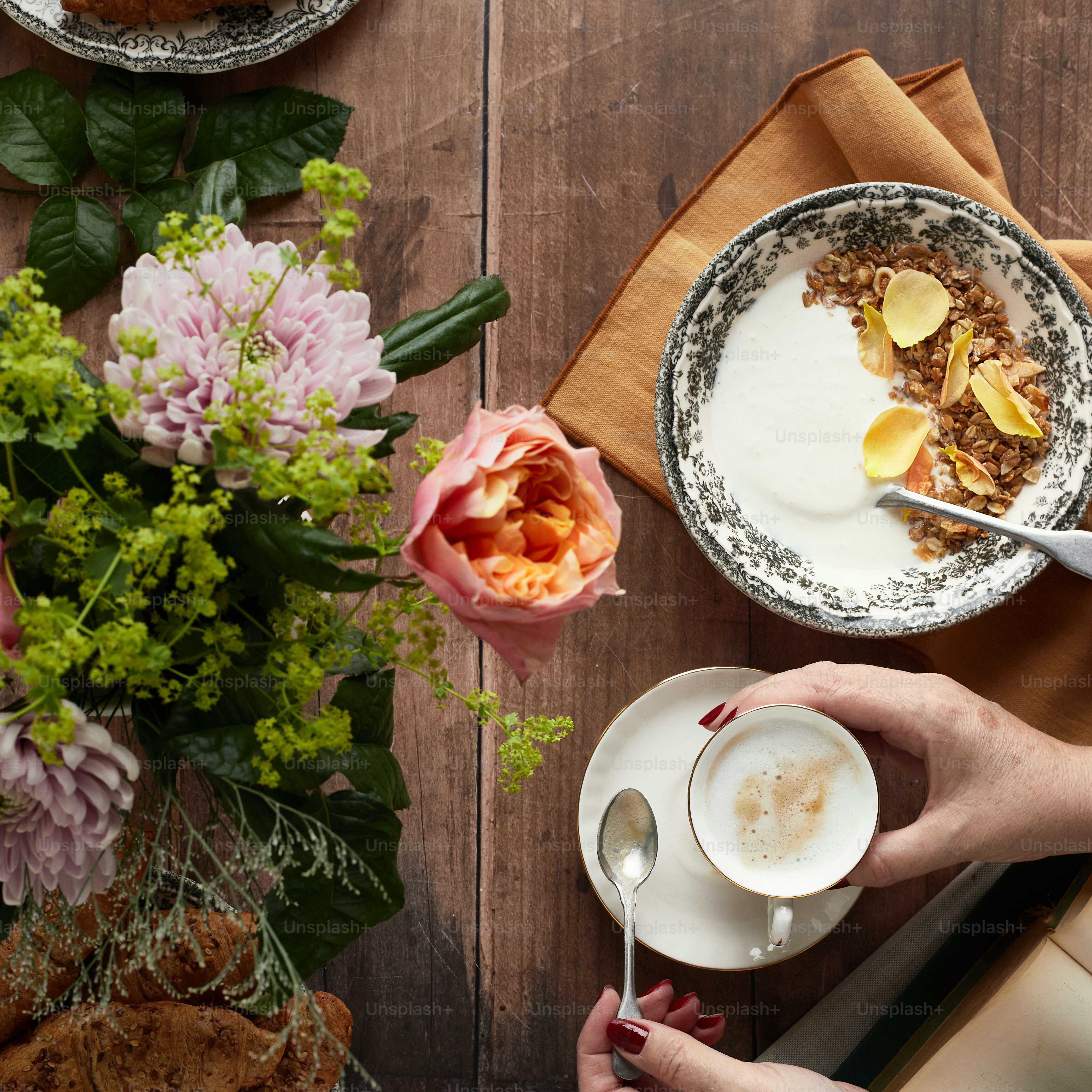 eine Person, die eine Tasse Kaffee und einen Teller mit Essen hält