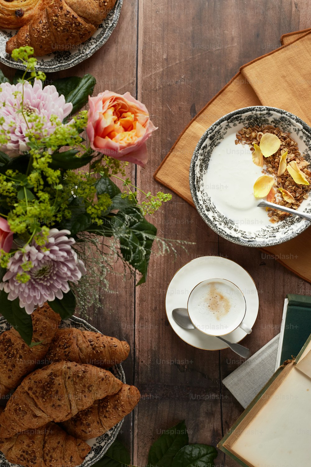 una mesa de madera cubierta con platos de comida y flores