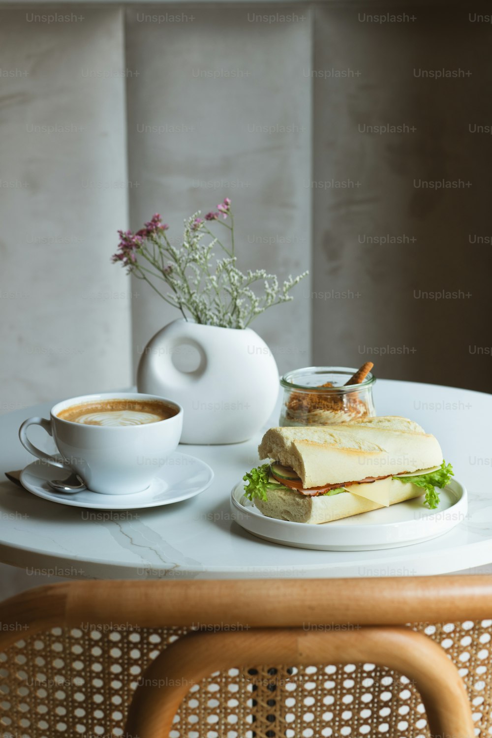 a table with a sandwich and a cup of coffee