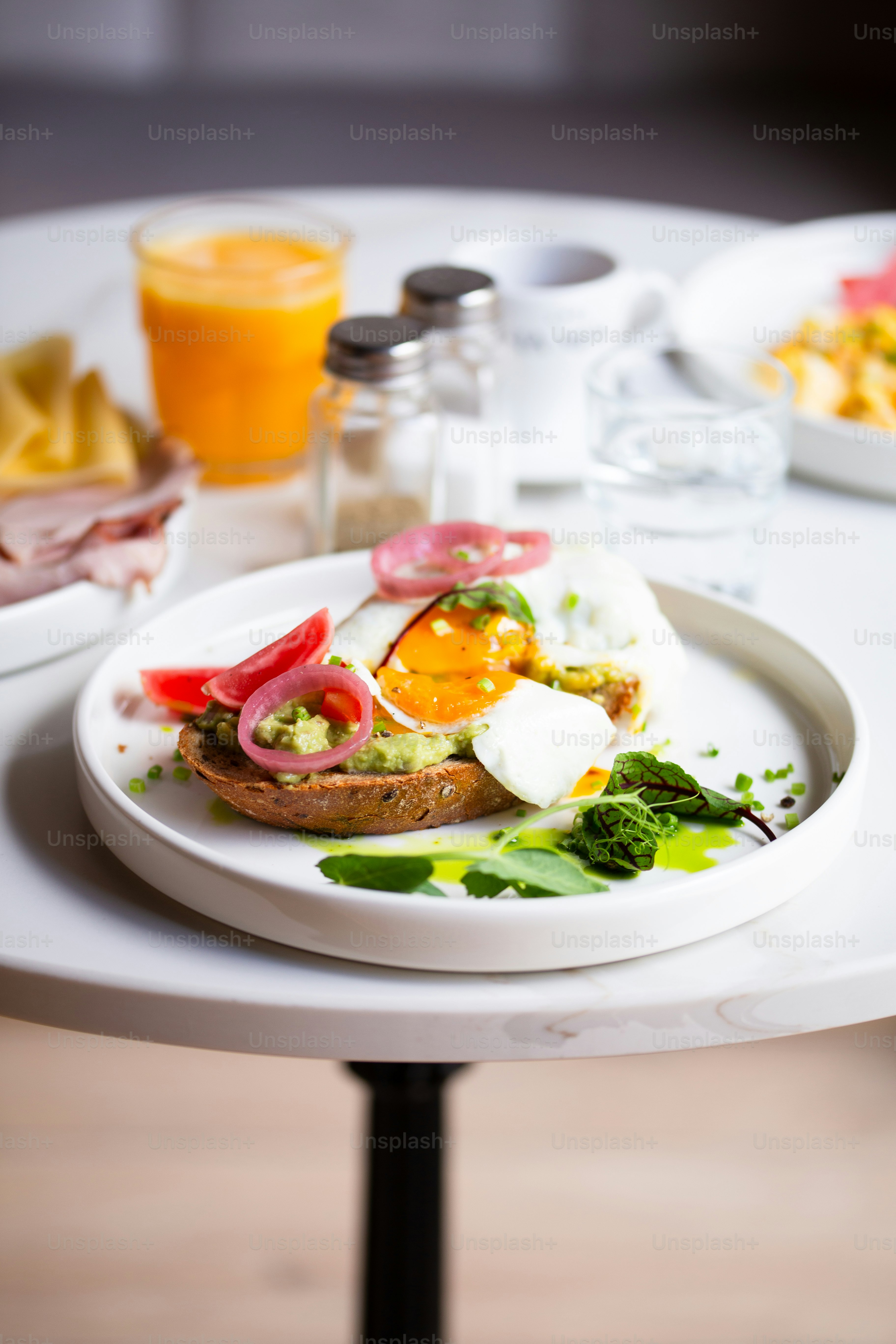 a plate of food on a table with a glass of orange juice