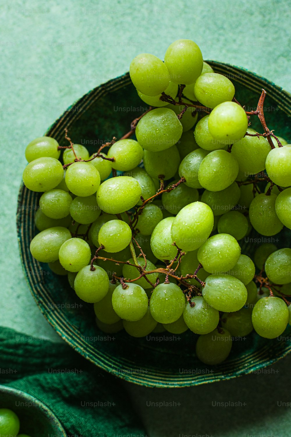 a bowl filled with green grapes on top of a table