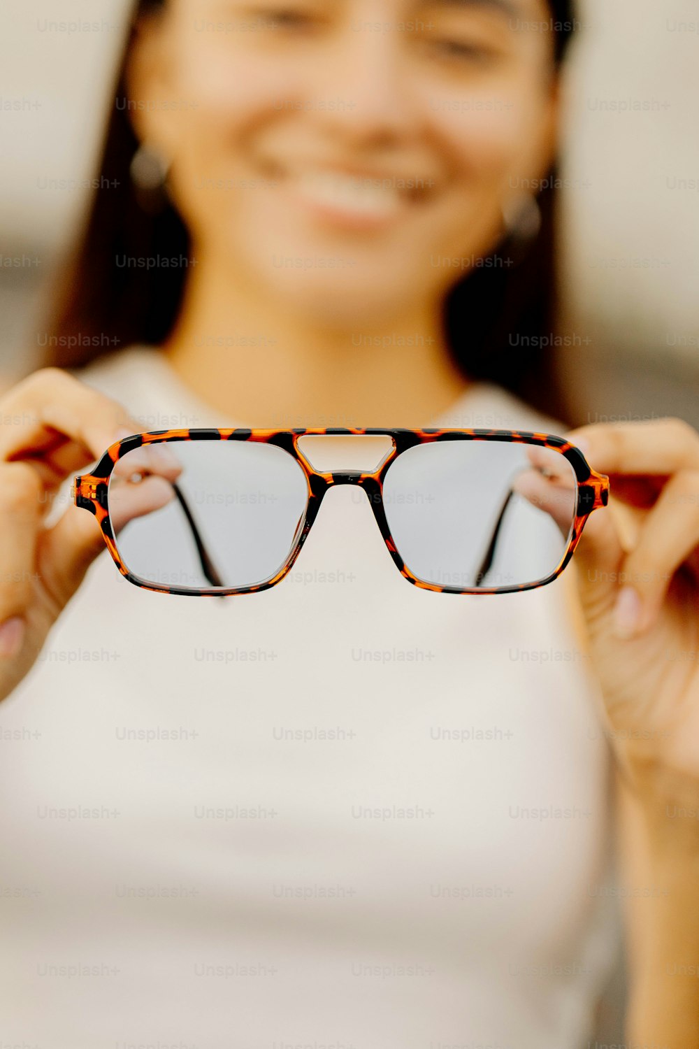 a woman holding up a pair of glasses