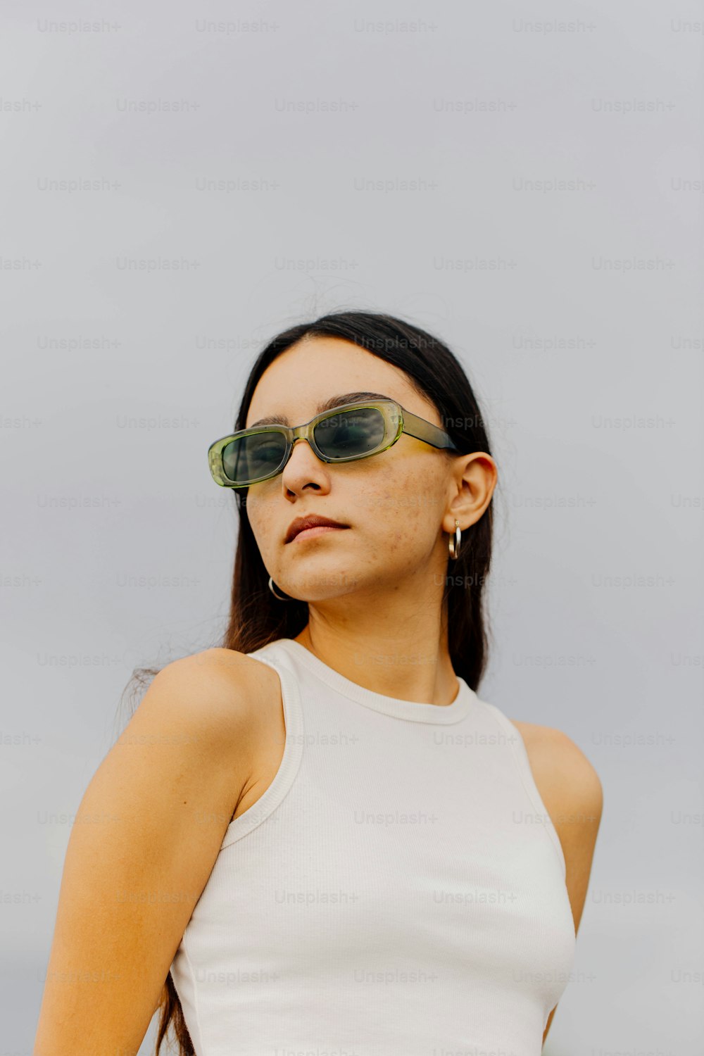 Una mujer con gafas de sol y una blusa blanca