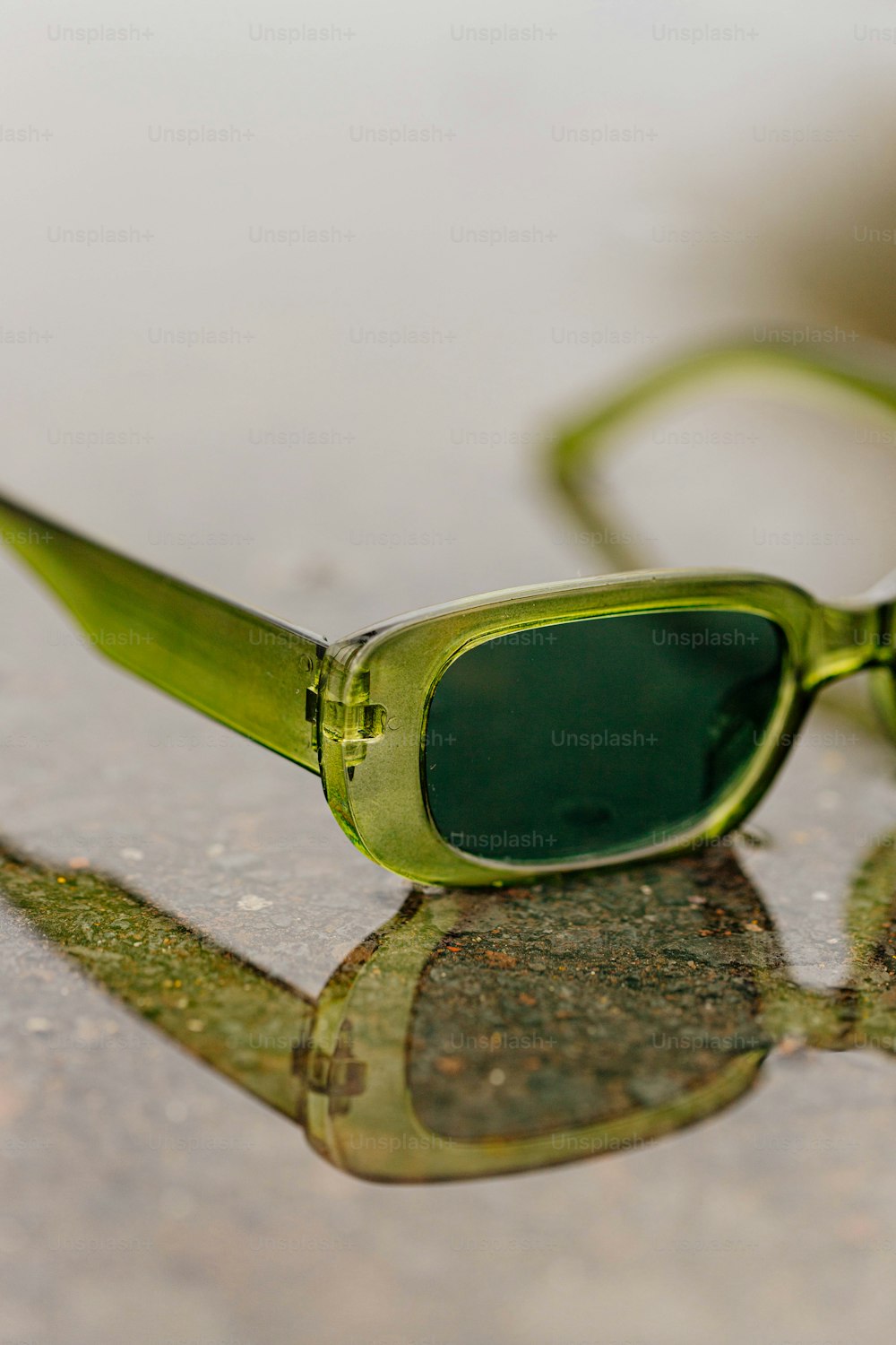 a pair of green sunglasses sitting on top of a table