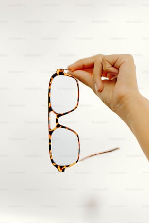 a person holding up a pair of glasses