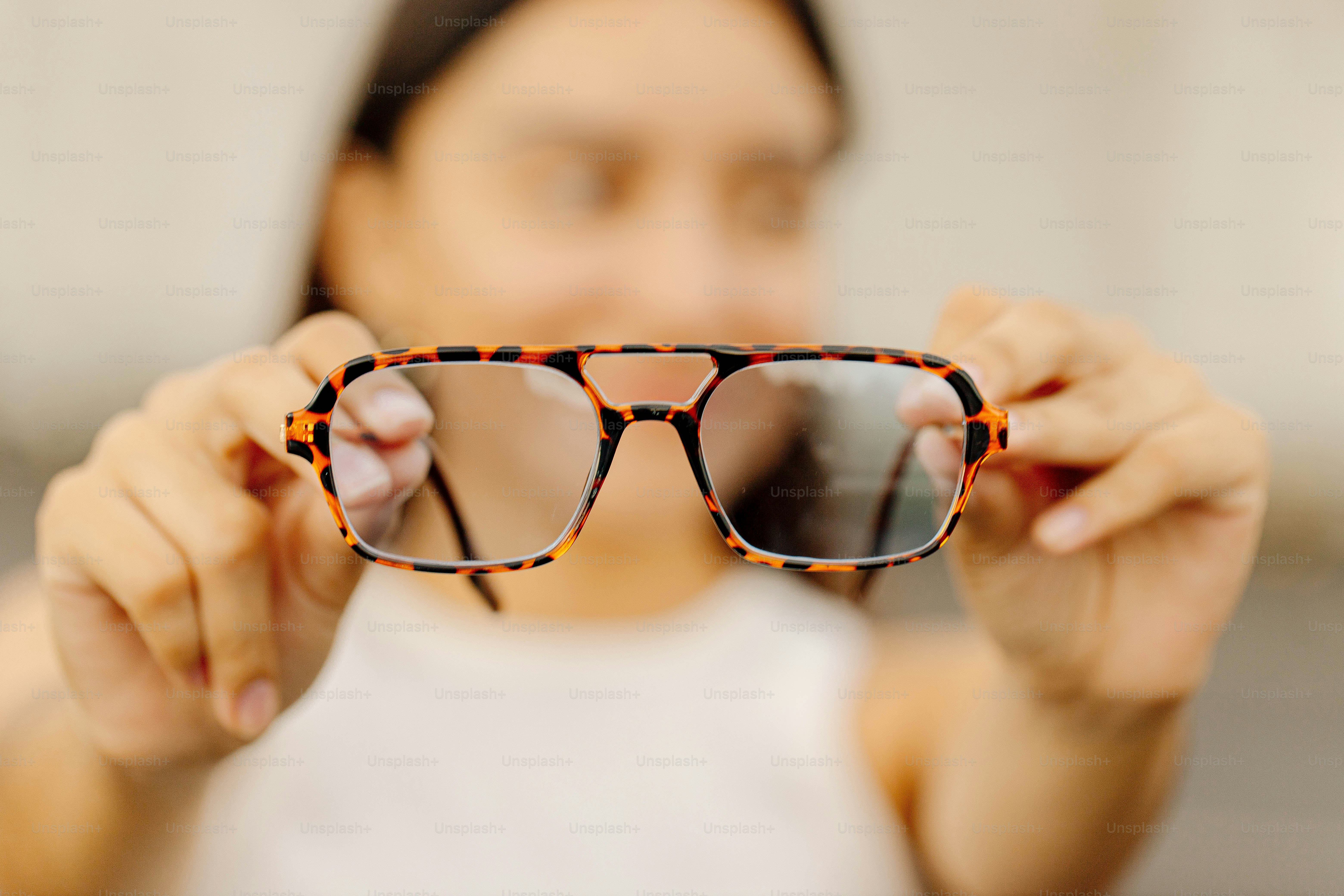 a woman holding up a pair of glasses
