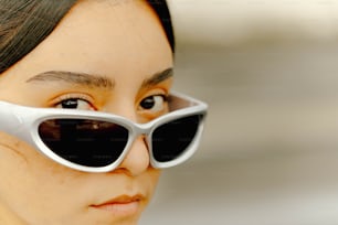 a woman wearing a pair of white sunglasses