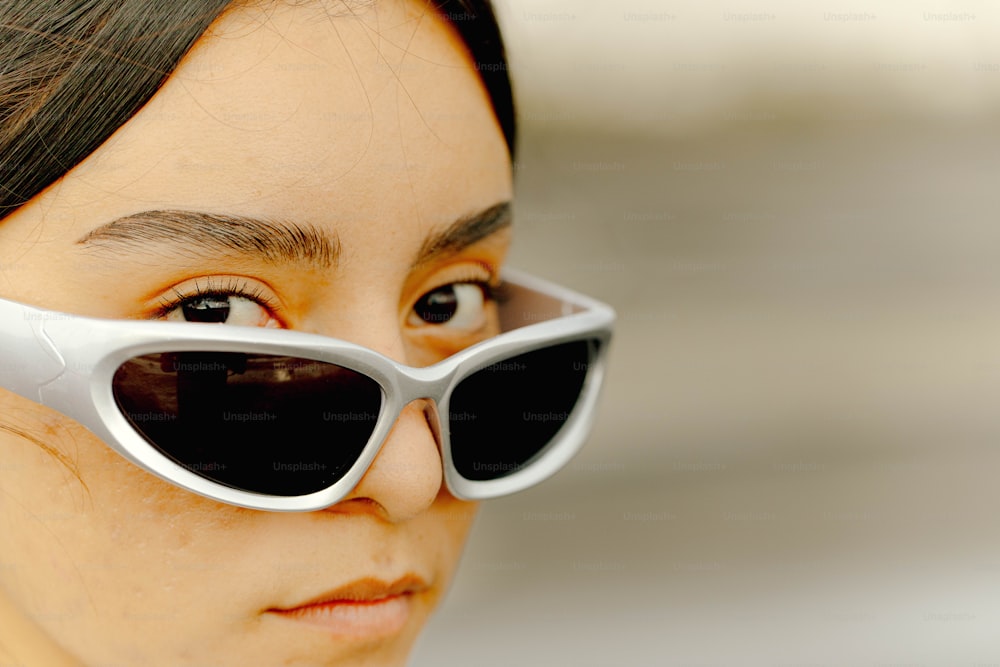 a woman wearing a pair of white sunglasses