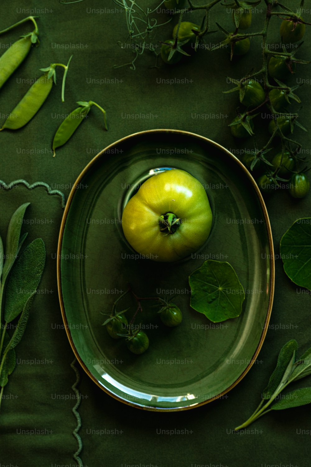 a green apple sitting on top of a green plate