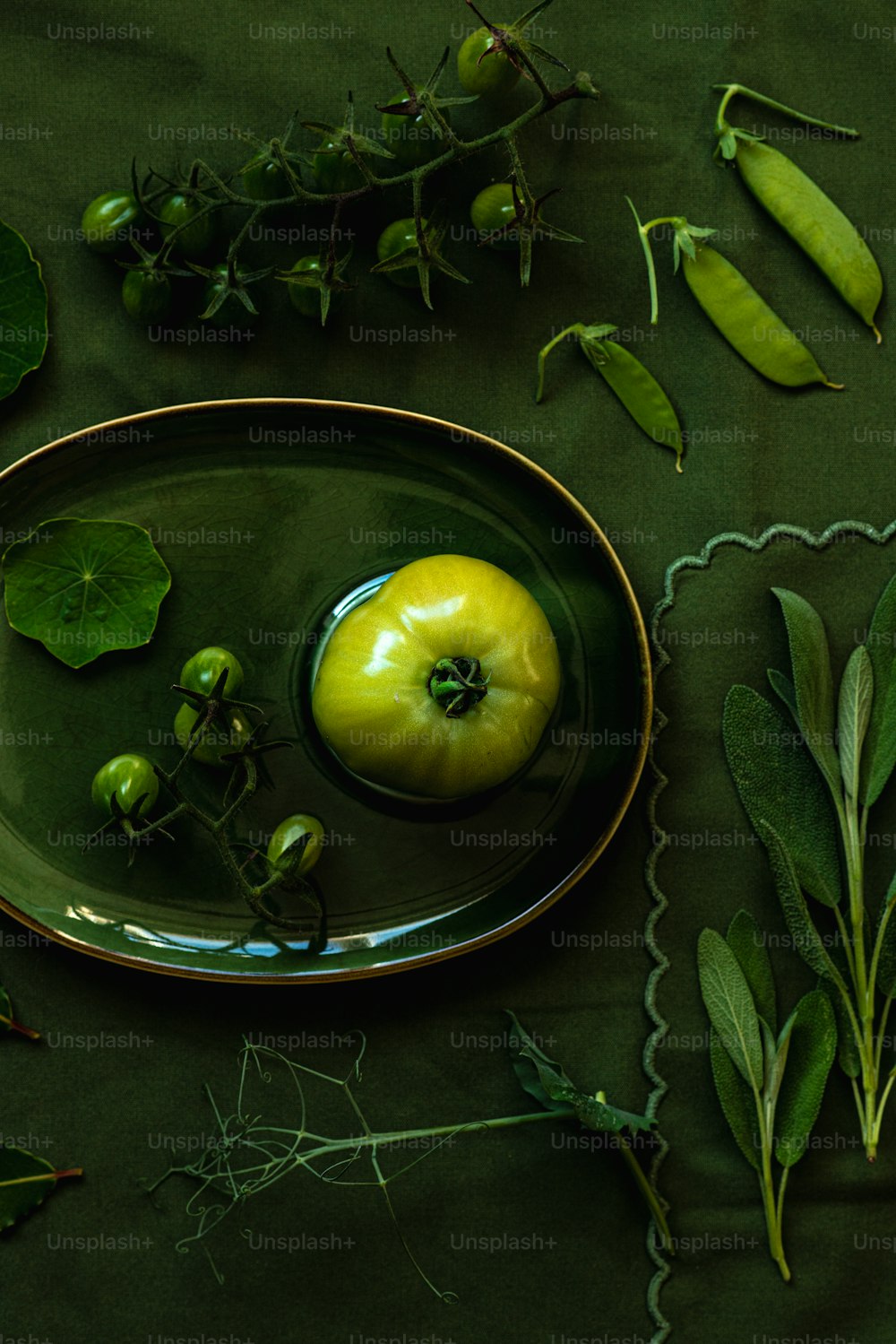 a green apple sitting on top of a green plate