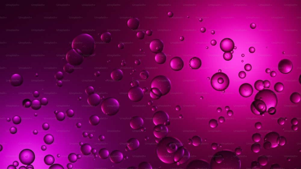 Un montón de gotas de agua sobre un fondo púrpura y rosa