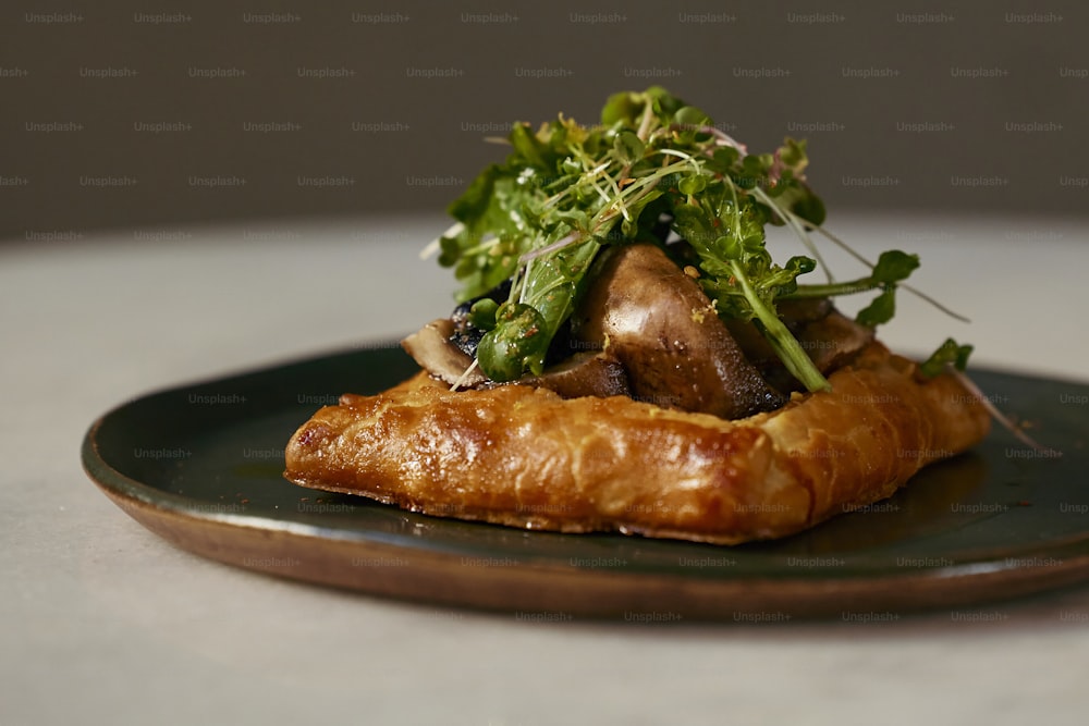 a piece of croissant topped with mushrooms and greens