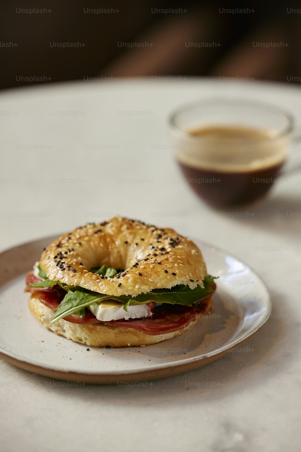 a bagel sandwich sitting on top of a white plate