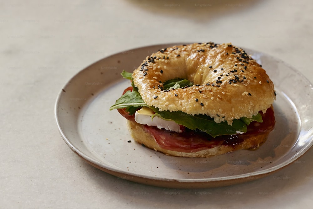 a bagel sandwich on a plate on a table