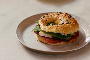 a bagel sandwich on a plate on a table